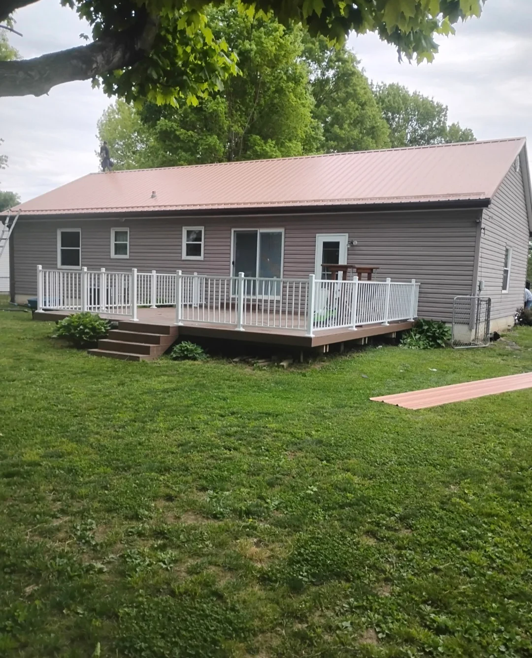 Standing seam metal roof and new composite deck with white railings on residential home