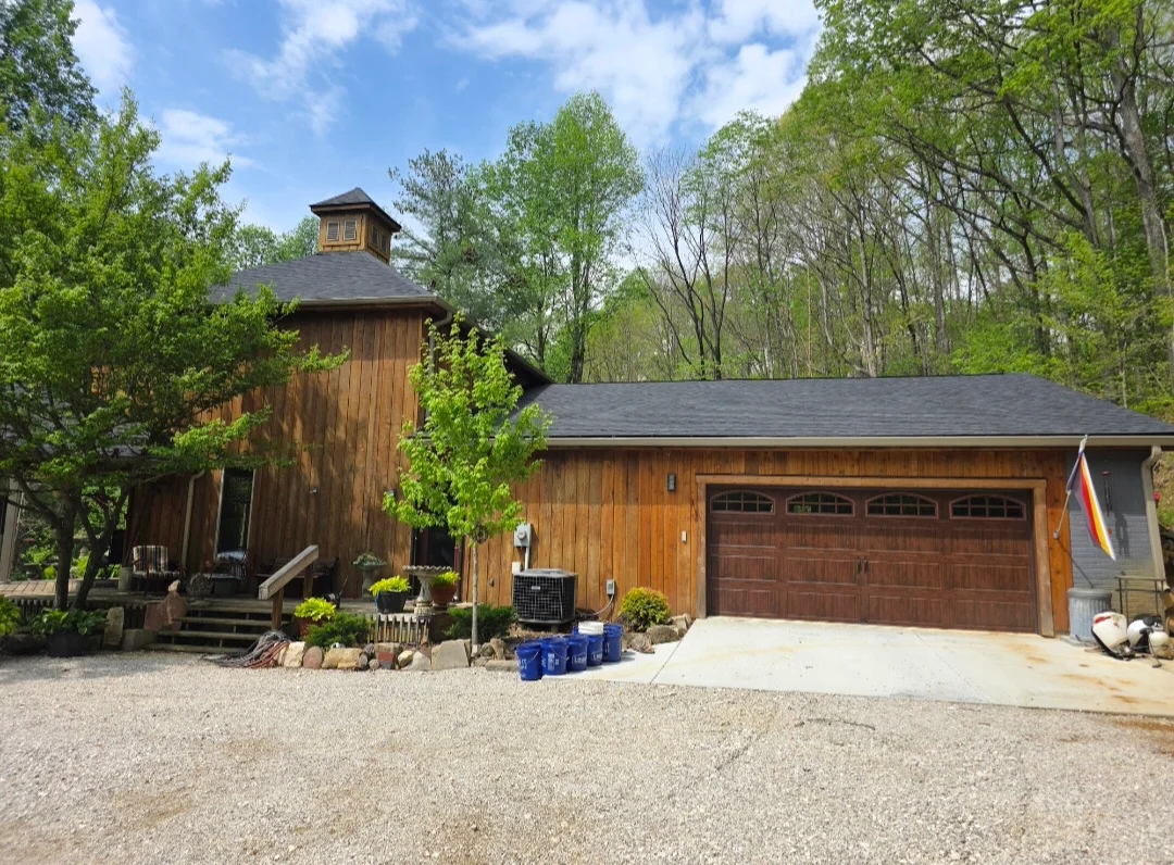 Dark architectural shingles on barn-style home with cupola and two-car garage
