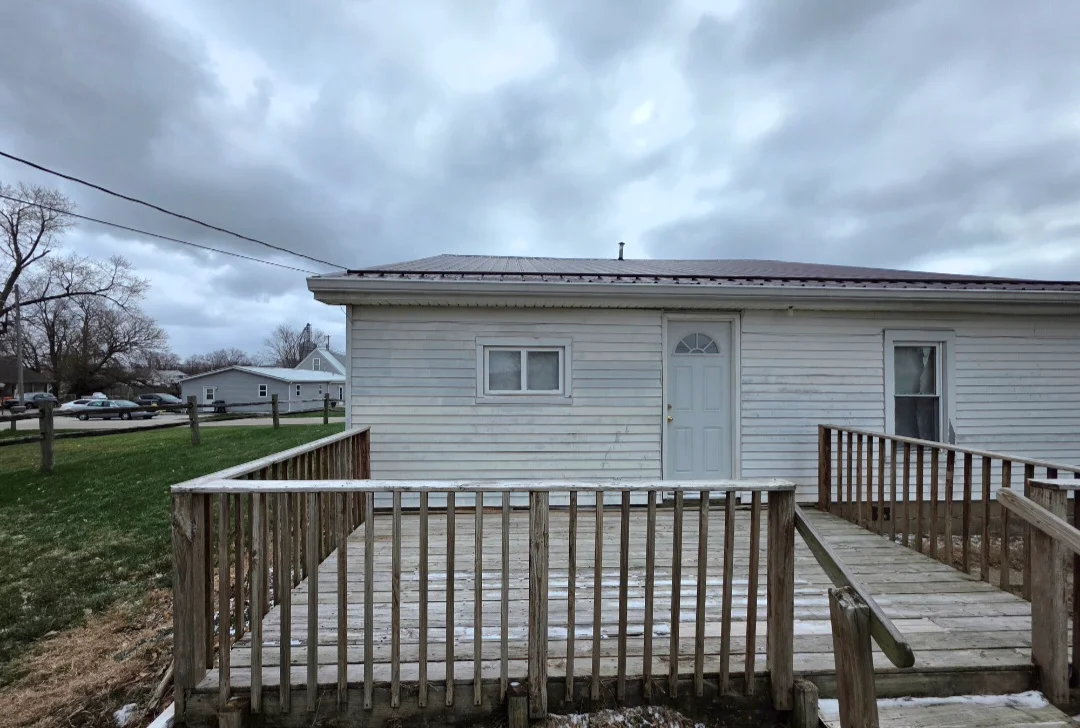 Mobile home with new vinyl siding and wooden deck with railings