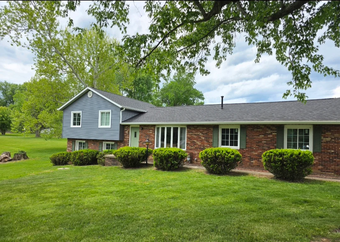 Charcoal gray architectural shingle roof on brick split-level home with updated siding