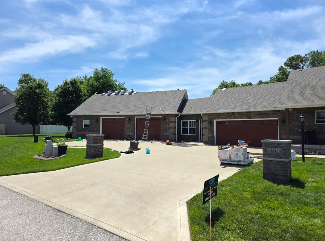 Brick home with newly installed gray asphalt shingle roof and multiple roof planes