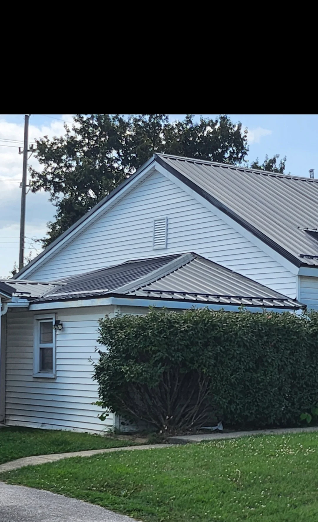 Standing seam metal roof and vinyl siding on residential home with gable design