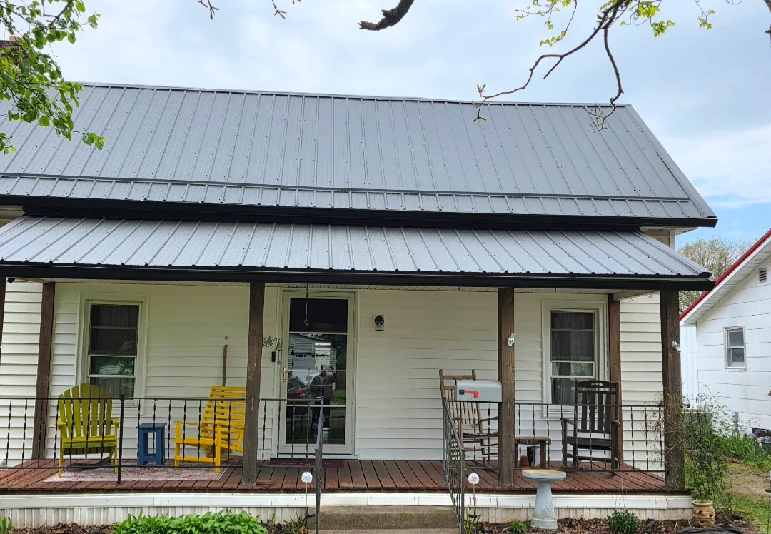 Gray standing seam metal roof with porch overhang on residential home