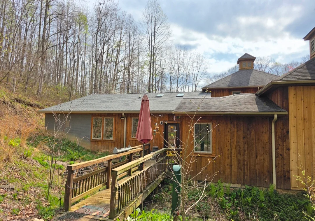 Gray architectural shingle roof on multi-level home with cupola and wood deck