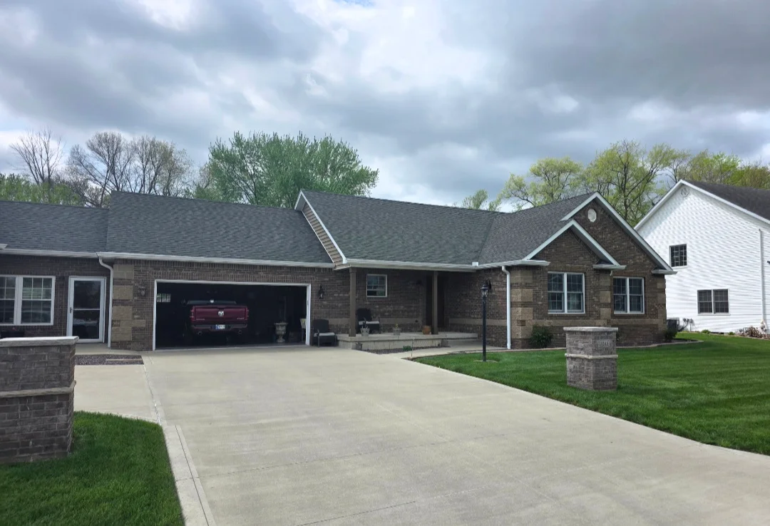 Brick home with new charcoal gray asphalt shingle roof and attached garage