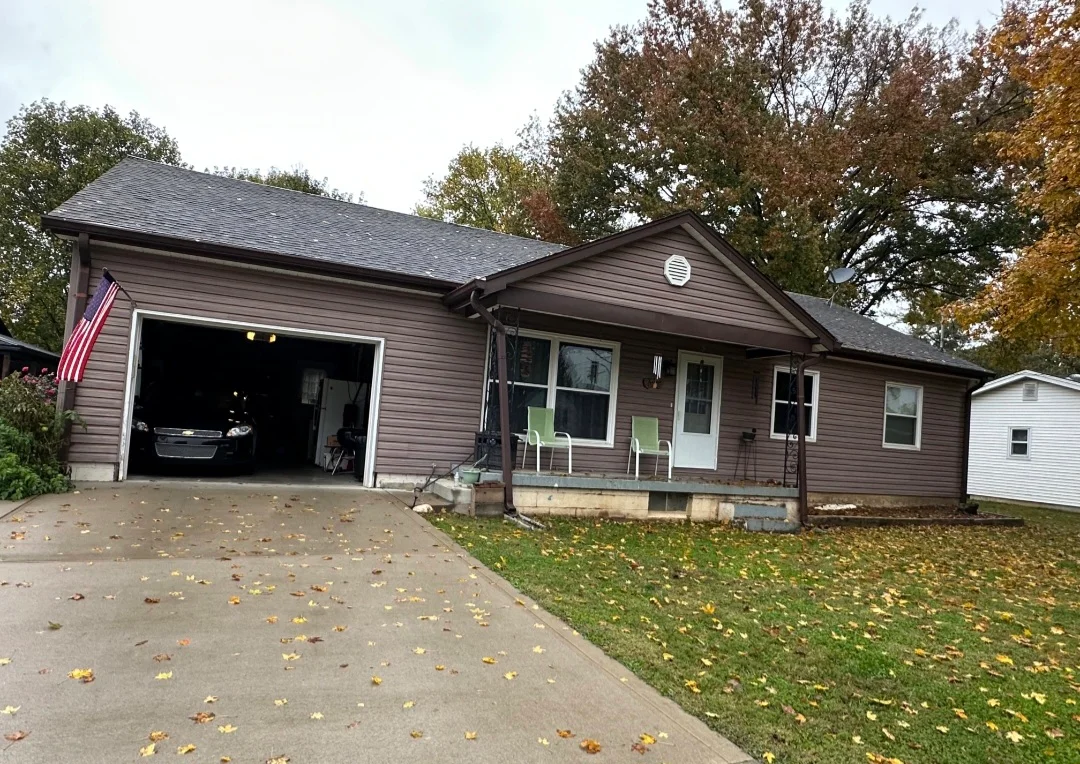 Charcoal gray asphalt shingle roof on ranch-style home with open garage